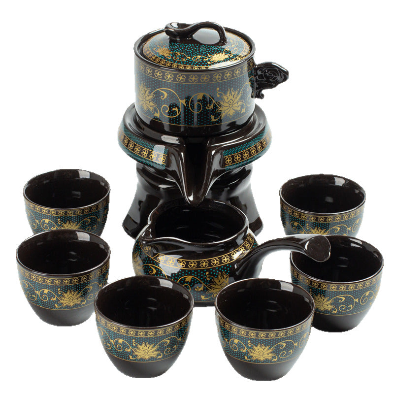 Black and gold ceramic tea set with teapot and cups on a white background